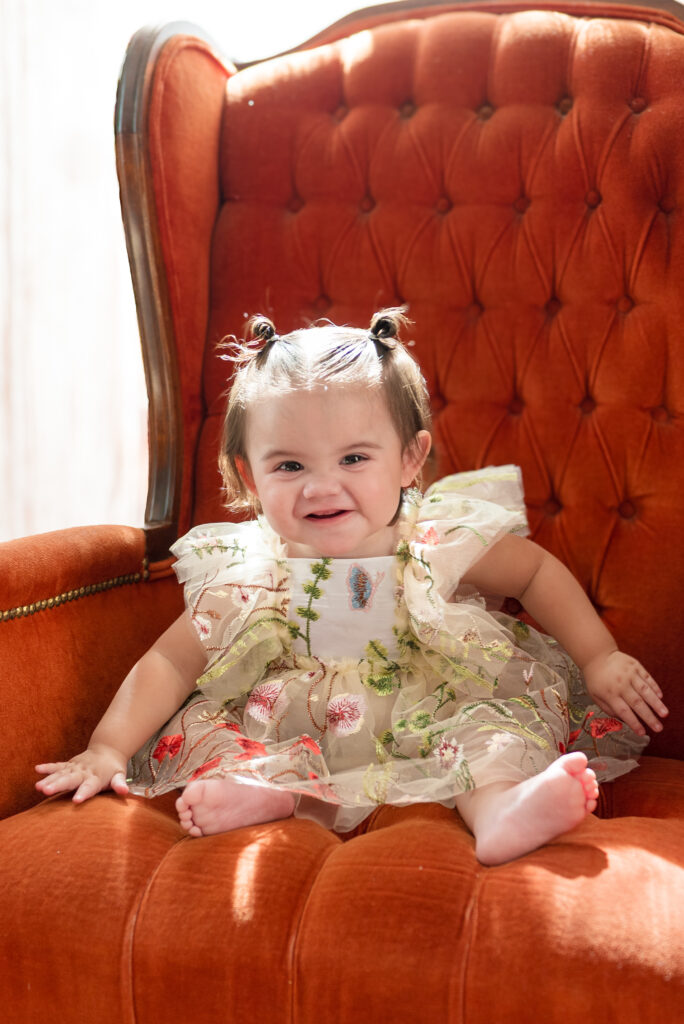 surprise pediatrician patient young girl sitting in rust velvet chair
