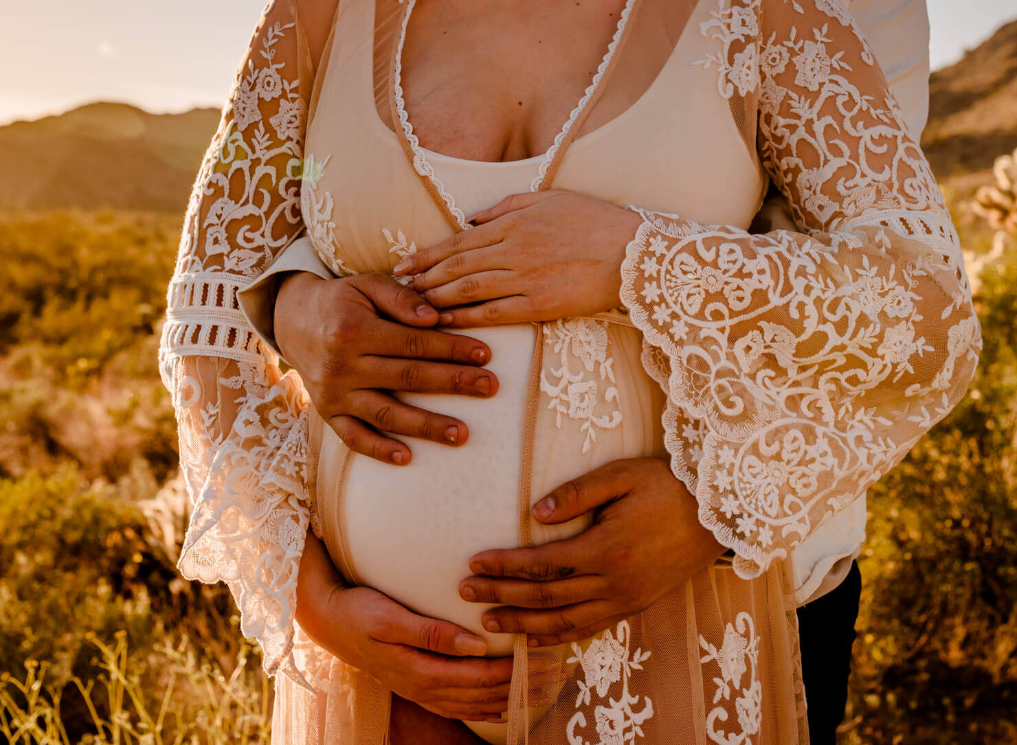 belly and hands of parents-to-be looking for an Arizona midwife