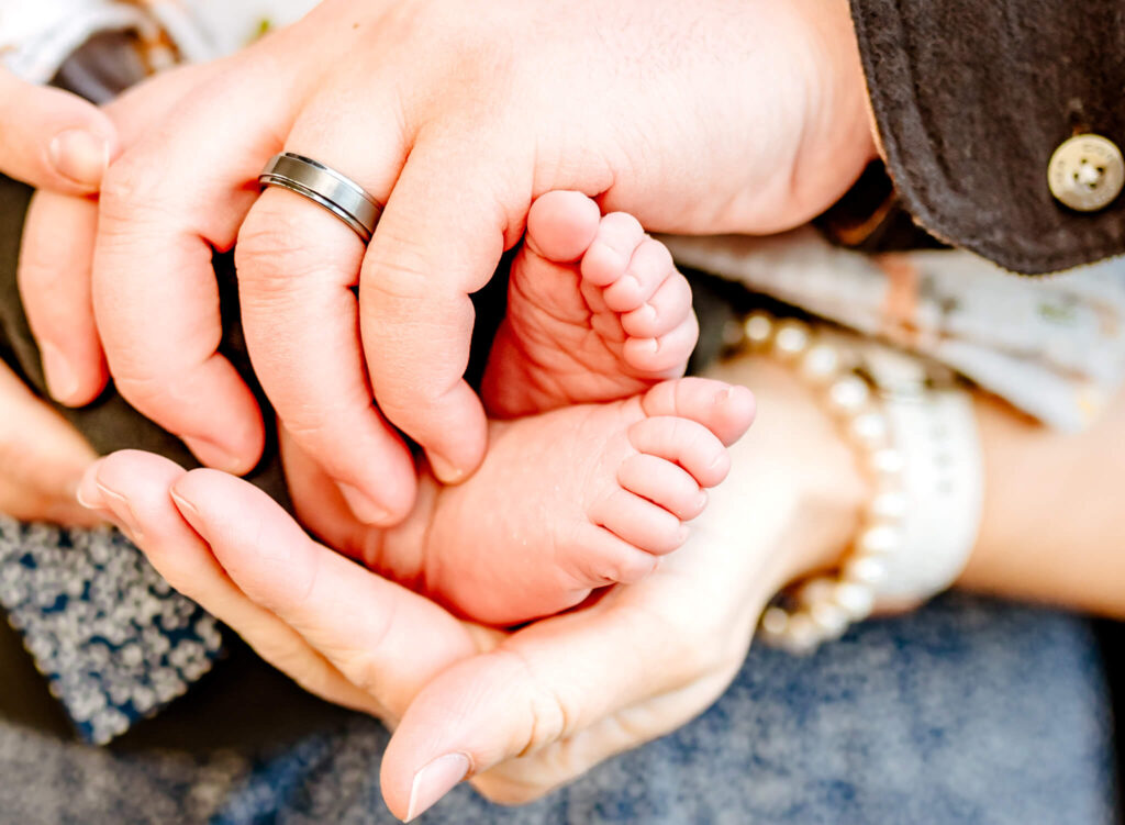 Phoenix, AZ parents holding newborn feet for maternity keepsake hand casting