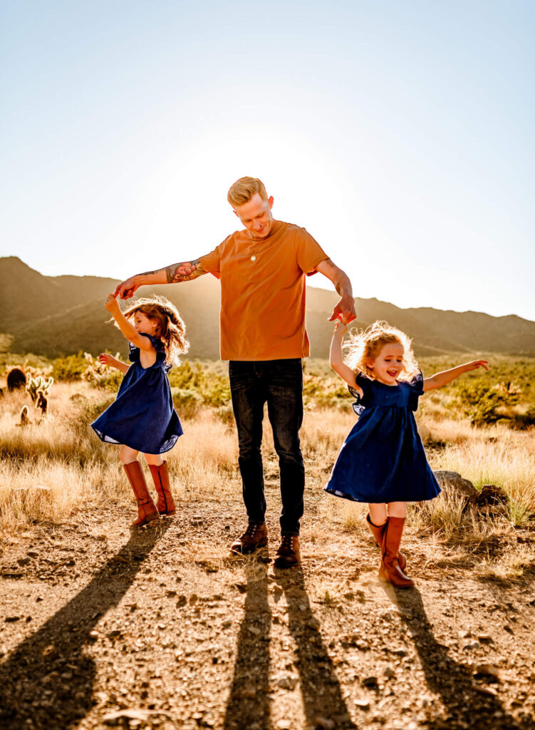 dad twirling two daughters perfect age for sweet pea baby rentals trip to Phoenix