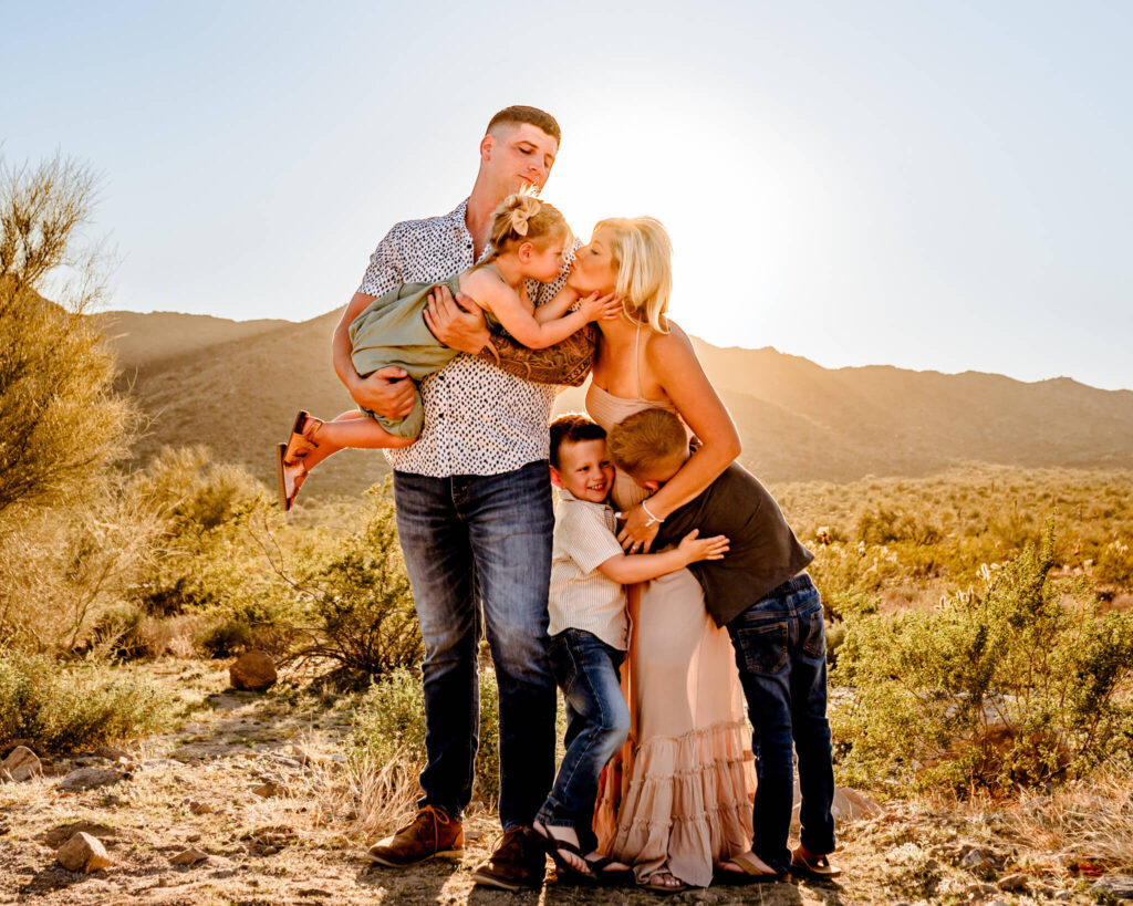 family of 5 hugging in desert on trip to Phoenix with sweet pea baby rentals