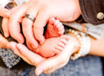 hands holding newborn feet, parents looking for a cloth diaper service in Phoenix