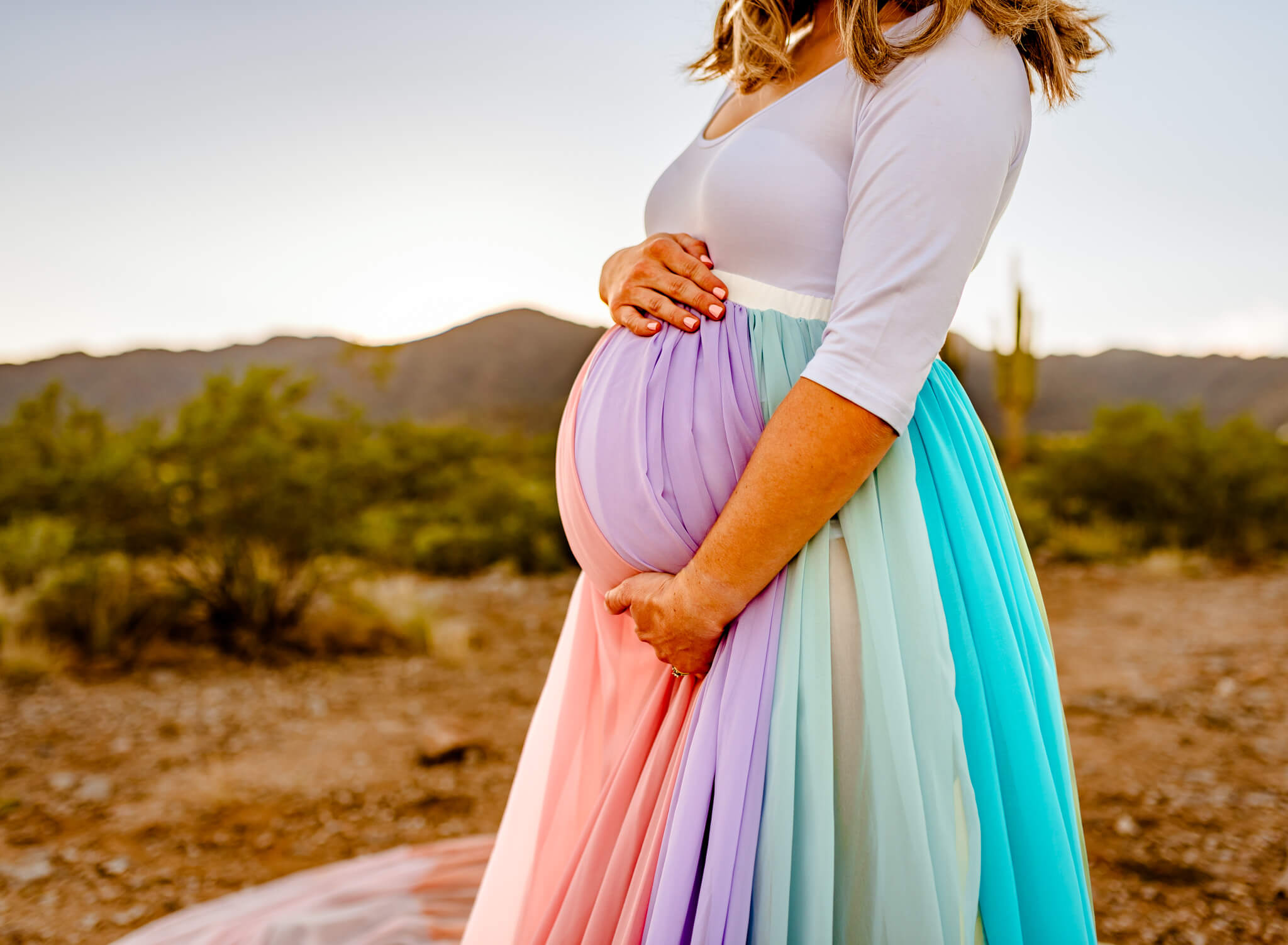 Premier Care for women mom's hands on baby bump with rainbow skirt
