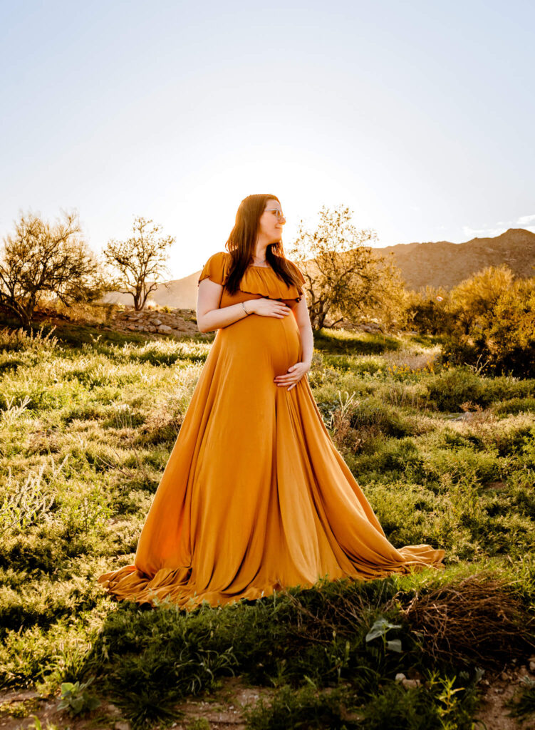 mom in yellow gown holding baby bump seeking premier care