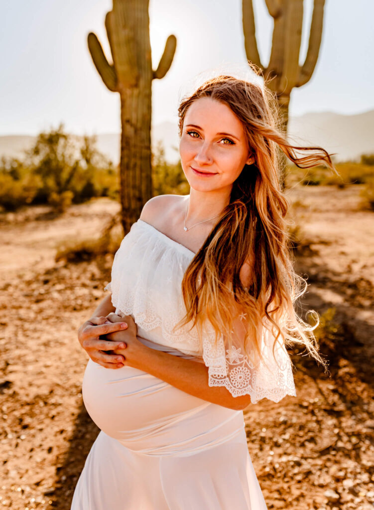 first time mom who found premier care for women, holding pregnancy belly in desert