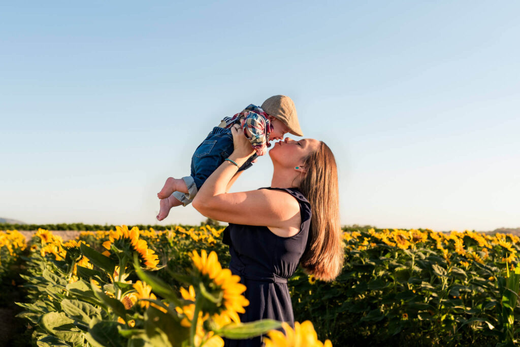Phoenix mother holds young son for a kiss nearby an Arizona corn maze