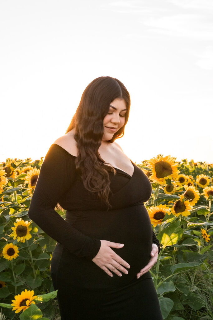 during the season for apple picking in phoenix AZ, expecting mother stands in flower field