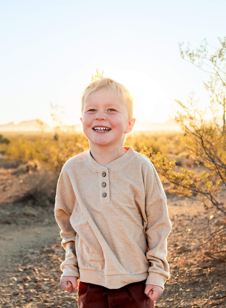 portrait of boy smiling beyond the camera talking about Christmas trees